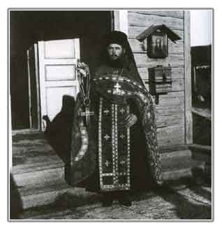 Монах с крестом прп. Макария Римлянина у входа в церковь Макарьевской пустыни (1900-е гг.)