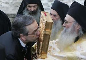 Премьер-министр Греции Антонис Самарас целует Евангелие по прибытии на Афон