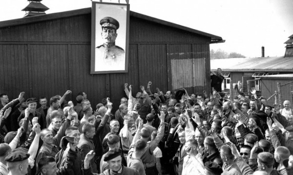 Советские пленные подняли портрет Иосифа Сталина в честь освобождения Бухенвальда. Многие из них транзитом проследуют из Бухенвальда в ГУЛАГ
