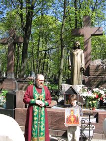 Священник Алексий Мороз совершает молебен на Новодевичьем кладбище