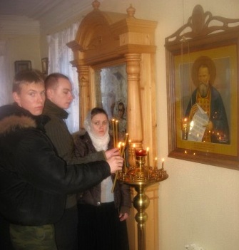 Участники Первого Иоанновского авто-паломничества возжигают свечи у иконы праведного Иоанна Кронштадтского (Село Сура 2 января 2009 года)