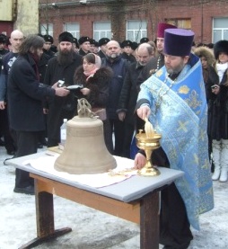 Протоиерей Александр Ганьжин окропляет колокол для храма иконы Божией Матери Милующей