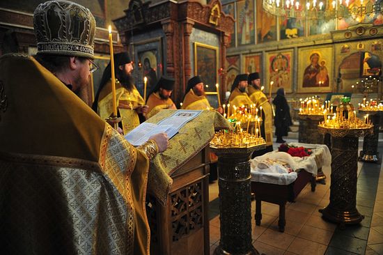 Архимандрит Тихон читает разрешительную молитву над усопшей Евгенией Матвеевной Грикой.