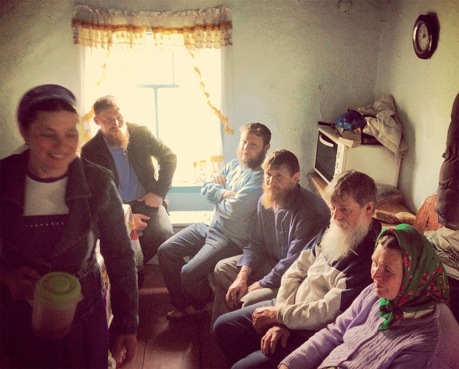Духовный наставник Федор Савельевич (с седой бородой), за ним — Ульян, глава общины. Женщина с кувшином в руках – Агафья. В кувшине — брага