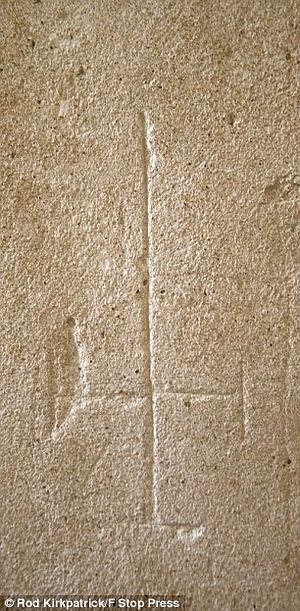 Перевернутый крест на внутренней стене, высеченный сатанистами. Фото: Род Киркпатрик / F Stop Press